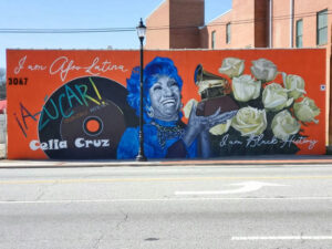 Photo by Atlanta Street Art Map on March 24, 2025. Pode ser uma imagem de parede de tijolos e texto que diz "Jam o am Afor AfroLatina Latina jAZUCARI UCAR! 3067 [እዕራዳጄ elia Cruz am dam Black BlackHistory History".