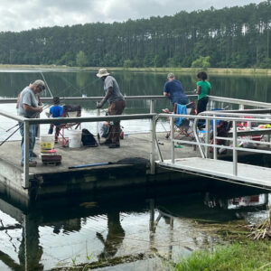 Photo by Camden County, Georgia on June 09, 2025. May be an image of 5 people, people fishing, lake, boathouse and text.