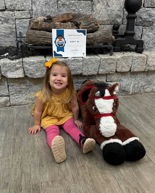 Photo by Fulton County Library System on December 09, 2025. May be an image of baby, smiling, pony, brick wall and text.